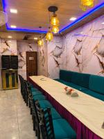 Una mesa larga y sillas en una habitación con una mesa. en Punjabeez Restaurant, en Patiala