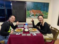 duas mulheres sentadas numa mesa com pratos de comida em Hotel Happy Land em Chitwan