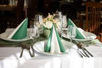 a table with green napkins and plates on a table at Hotel Szeifert in Sovata
