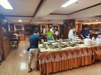 a group of people standing around a table with food at Yamadaya Apartment in Phra Nakhon Si Ayutthaya