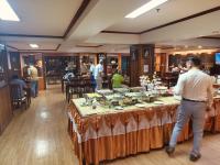 a man standing at a buffet table in a restaurant at Yamadaya Apartment in Phra Nakhon Si Ayutthaya