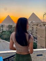 GizaにあるNew fort Night Pyramids Hotelの女性がピラミッドを眺めている