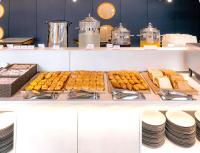 a buffet filled with pastries and plates on a table at Sokcho Mari Vista Hotel in Sokcho
