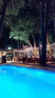 a pool at night with people sitting at a restaurant at Bosque Las Delfinas in Punta Colorada