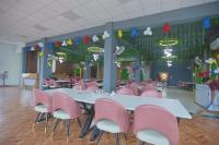 Un comedor con sillas rosas y una mesa con sillas. en Hotel Om Vilas, en Jait