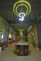 un restaurante con mesa, sillas y lámpara de araña en Hotel Om Vilas, en Jait