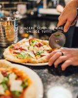 una persona tomando una rebanada de pizza de una mesa en Cascina De' Fagiolari, en Lastra a Signa