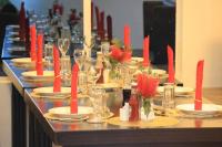 uma mesa longa com pratos e velas vermelhas em Highlands View Boutique Villas & Resort, Nyeri em Nyeri