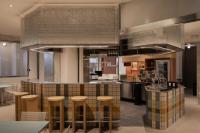 新加坡BEAT 1932 Hostel at Chinatown的厨房里有一个带凳子的吧台