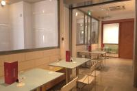 新加坡BEAT 1932 Hostel at Chinatown的一家餐厅，里面有桌椅和一个大窗户。