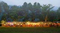 un grupo de personas sentadas en un restaurante con luces en Nature Retreat by the Waterfall, Toom Sara Village, 15mins to Ba Na Hills, en Mang Son