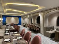 een eetkamer met lange tafels en stoelen bij Pinky Hotel in Dausa