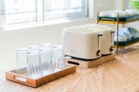 Una tostadora y vasos sobre una mesa de madera. en Sea Dragon Hotel Cát Bà & Aparment, en Cat Ba