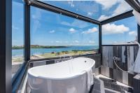 a bath tub in a bathroom with a view of the ocean at Malibu OceanView Homestay in Magong