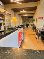 un ristorante con bancone, tavoli e sedie di Belo Hotel a Tomé-Açu