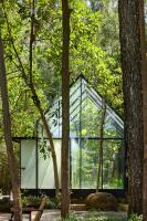 een glazen huis in het bos met bomen bij Kaya Retreat in Diyatalawa