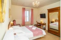 Un dormitorio con dos camas y un espejo. en Hôtel Restaurant Continental, en Évian-les-Bains
