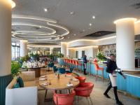 Un restaurante con mesas y sillas y gente caminando en él. en Executive Suite at Ellipse in Waterfall Midrand, en Midrand