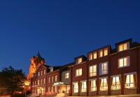 un edificio con una iglesia al fondo por la noche en Hotel von Euch, en Meppen