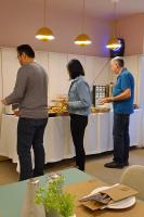 three people standing in a kitchen preparing food at M31Boutique Suites in Mellieħa