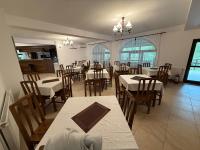 马拉亚Casa Lacului的摆放着白色桌椅的餐厅