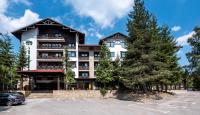 un edificio con un árbol en un estacionamiento en Lion Hotel Borovets, en Borovets