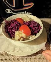 Un tazón de comida con huevos encima de arroz. en Rügen-Hotel, en Sassnitz