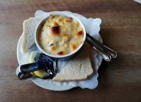 Un tazón de sopa en un plato con un poco de pan en Rügen-Hotel, en Sassnitz