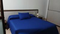 Una cama azul con una almohada azul en una habitación. en Domo - Guest-House Il Nespolo Fiorito, en Orosei