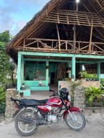 a red motorcycle parked in front of a building at Verani Beach Lodge in Makangale