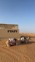 a group of three animals laying in the desert at FYAFY Bidiyah Bedouin Camp in Bidiyah