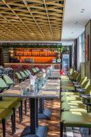 a dining room with long tables and green chairs at 上海艾菲花园酒店The Garden F in Shanghai