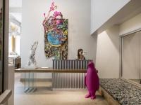 Un perro rosa sentado en el mostrador de recepción de un museo. en 21c Museum Hotel Durham, en Durham