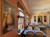 a restaurant with tables and chairs and a large painting on the wall at Hotel Casa Borghese in Senningerberg