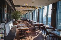 Un restaurante con mesas, sillas y ventanas. en Courtyard by Marriott Katowice City Center, en Katowice