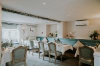 a dining room with white tables and chairs at Number Four at Stow in Stow on the Wold