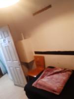 a small bedroom with a bed and a chair at VOB ENTERPRISEs in Chatham