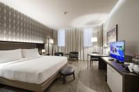 a hotel room with a bed and a desk with a computer at Doubletree By Hilton Pointe-Noire City Centre in Pointe-Noire