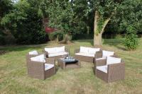 a group of wicker chairs and a table in a yard at Fleur House in Teloché