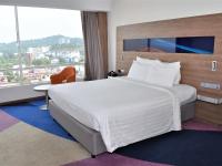 Una habitación de hotel con una cama grande y una ventana grande. en Novotel Taiping, en Taiping