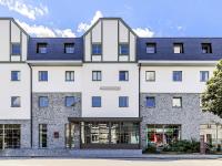 a large white building with blue roof at Mercure Han-sur-Lesse in Han-sur-Lesse