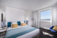 a hotel room with a bed and a large window at Golden Tulip Marseille Euromed in Marseille