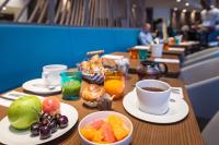 a table with cups of coffee and fruit on it at Golden Tulip Marseille Euromed in Marseille