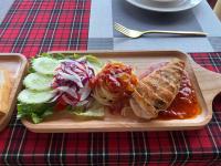 un plato de comida con un sándwich y ensalada en una mesa en Intimate Riverside Resort, en Vang Vieng