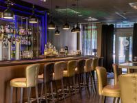 un bar con una fila de sillas en una habitación en Pullman Munich, en Múnich