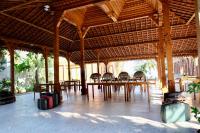 un grande padiglione in legno con tavoli, sedie e bagagli di Pulojava Resort a Karimunjawa