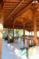 un grande padiglione in legno con tavoli e sedie di Pulojava Resort a Karimunjawa