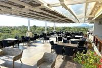 a restaurant with tables and chairs on a balcony at Likithos Village in Agios Georgios