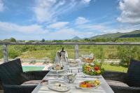 a table with food and wine on a balcony with a view at Likithos Village in Agios Georgios