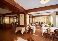 a dining room with white tables and chairs at Villa Alpina Hotel in Forni di Sopra